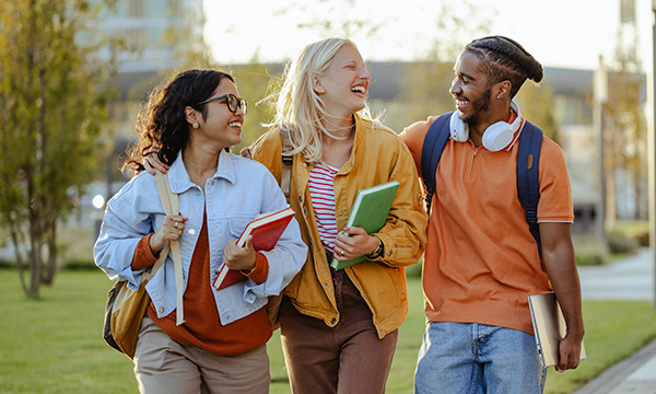 A group of three college students walking together